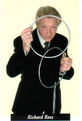 Richard Ross sosteniendo dos anillas enlazadas frente a la cámara